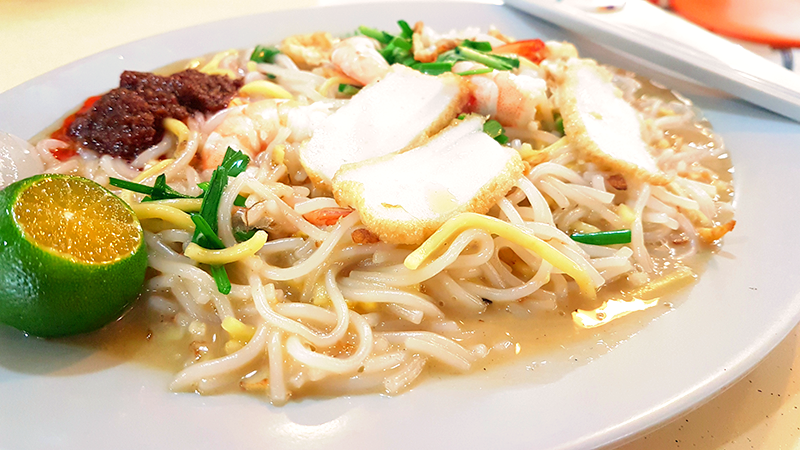 Singapore Hokkien mee uses thick yellow Hokkien noodles and beehoon (rice vermicelli), which are cooked with prawns, pork belly, chives, egg, squid and fish cake, topped off with sambal belacan and lime. From Shutterstock.